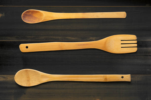 istock Wooden spoons and fork. On dark wooden table. Top view. 1249355606
