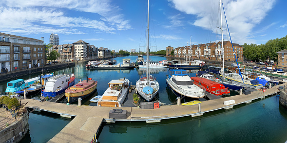 A large collection of vessels moored by jetties in St Katharine Docks near Tower Bridge in London.
