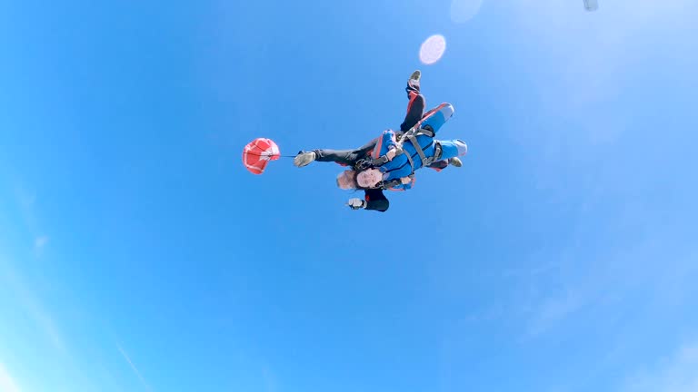 Instructor and woman are jumping out of an airplane with a parachute.