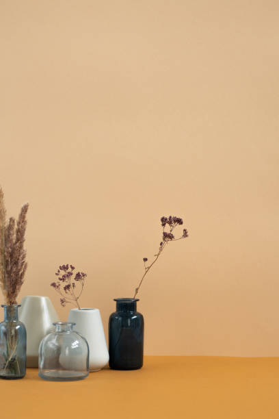istock Ceramic and glass vases with dried wildflowers and spikes standing on table 1249361085