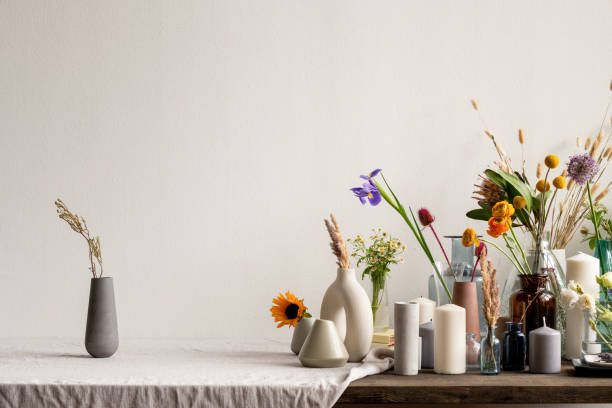 istock Black handmade ceramic or clay jug with dried wildflowers standing on table 1249361163