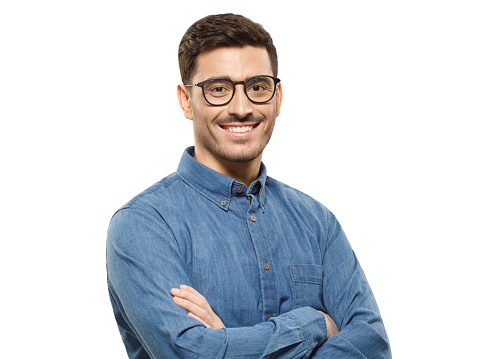 Portrait of young handsome smiling business guy wearing blue shirt and glasses, feeling confident with crossed arms, isolated on gray background