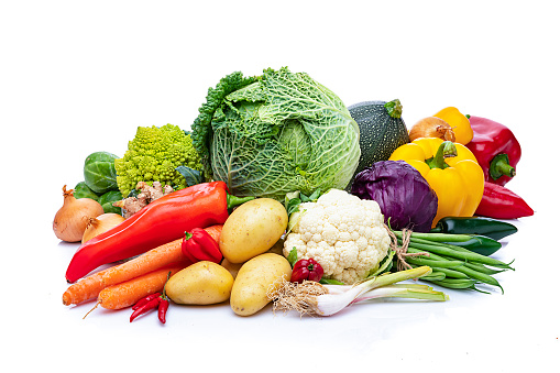 Healthy food: fresh multicolored organic vegetables for preparing a healthy meal arranged in a heap isolated on white background. Vegetables included in the composition are tomatoes, onion, carrot, green beans, bell pepper, chili pepper, herbs, cabbage, potatoes, among others. High resolution 42Mp studio digital capture taken with Sony A7rII and Sony FE 90mm f2.8 macro G OSS lens