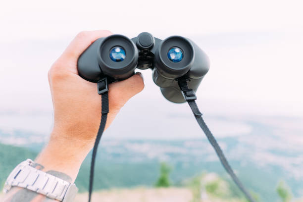 istock Male hand with binoculars in nature, pov. 1249362232