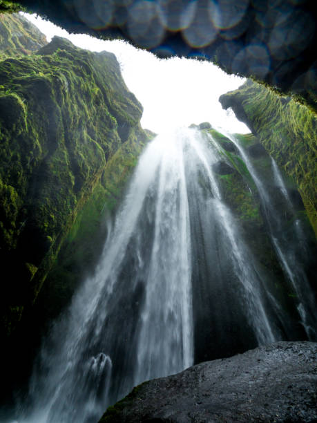 low angle photography of the hidden refreshing Gljufrabui waterfall with drops on the camera lens in a mysterious Icelandic cave near Storidalur