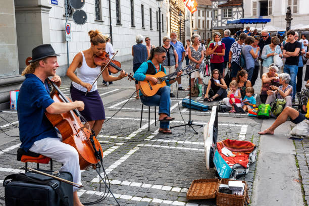 Street musician at Lucerne, Switzerland Lucerne, Switzerland - August 22, 2018: The bare brass band busking at Lucerne, Switzerland. Young boys and girls are earning money by using classic musical instruments (trombone, saxophone, oboe, drums) in street of Geneva. They are street musicians. lucerne switzerland stock pictures, royalty-free photos & images