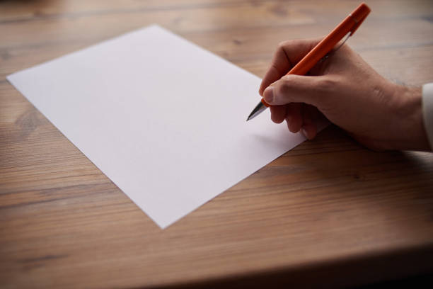istock a man writes on a white sheet of paper 1249364413