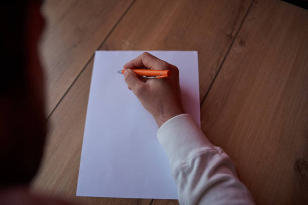 istock a man writes on a white sheet of paper 1249364514