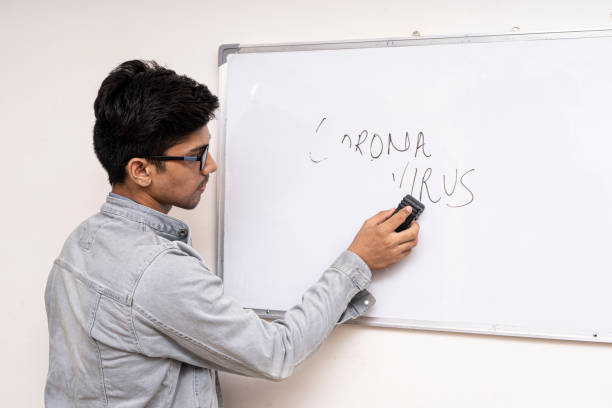 istock A young boy in denims erasing corona virus written on a white board, representing that corona virus will be gone soon. 1249365159