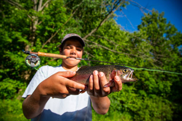 istock A young fly-fisherman with a rainbow trout 1249365240