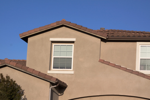 Stucco home exterior against a clear blue sky. Typical Southern California architectural style.