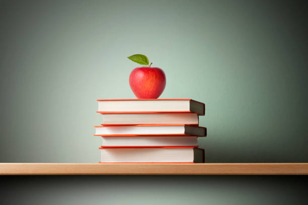 istock Stack of books with a red apple on the shelf 1249366405