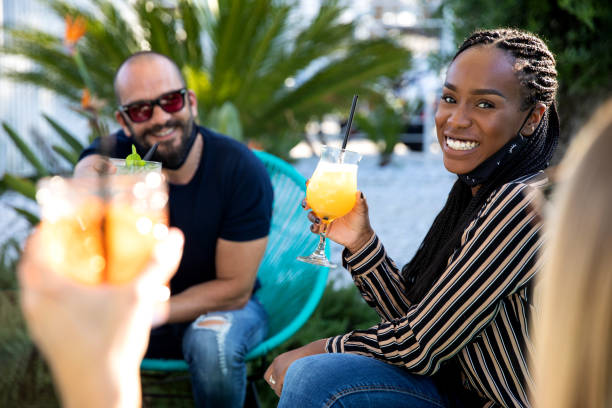 istock Happy group of multi ethnic friends enjoying some refreshing drinks wearing protective face mask 1249367810