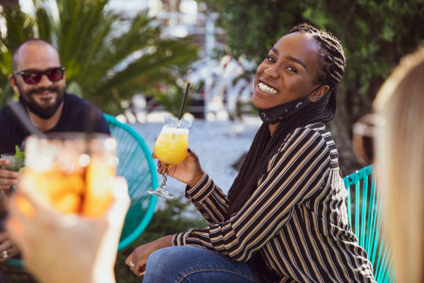 istock Happy group of multi ethnic friends enjoying some refreshing drinks wearing protective face mask 1249368801
