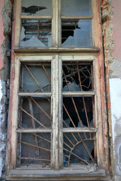 istock Old wooden window with a lattice and broken glass 1249369647