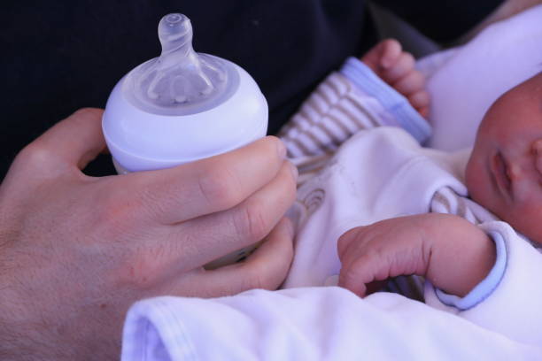 istock Father feeding a newborn baby 1249369657