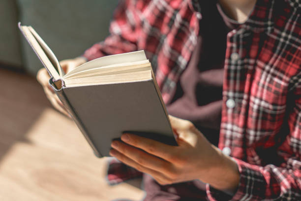 istock close up person hands holding the book and reading, get some knowledge 1249369734