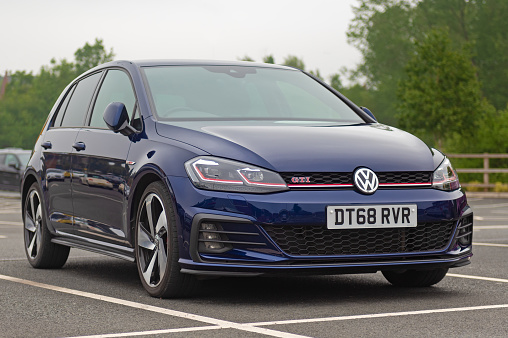 Staffordshire, England, UK - 13 June 2020: A Volkswagen Golf GTI Mk 7 facelift version in Atlantic Blue paint.