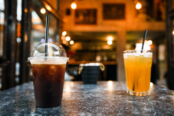 冷たいコーヒーとオレンジの飲み物でおしゃべりする人々 - coffee ice cube iced coffee tea ストックフォトと画像