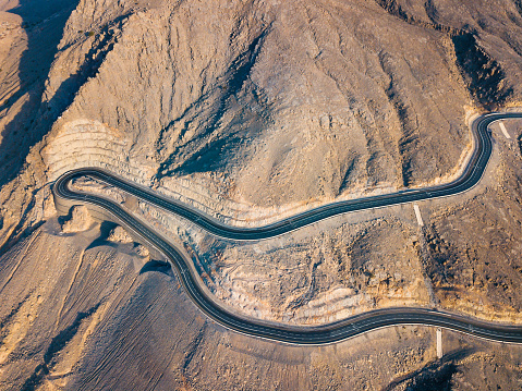 Winding desert road on Jebel Jais sandstone mountain in Ras Al Khaimah emirate or United Arab Emirates