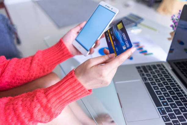 istock Female hands holding smartphone and using credit card 1249374835