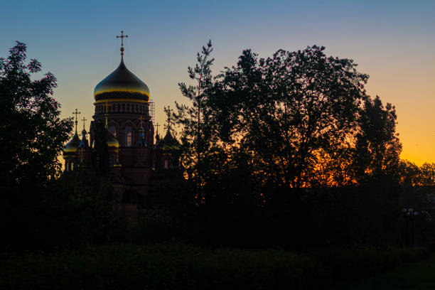 Orthodox Russian temple with golden domes on a sunset background