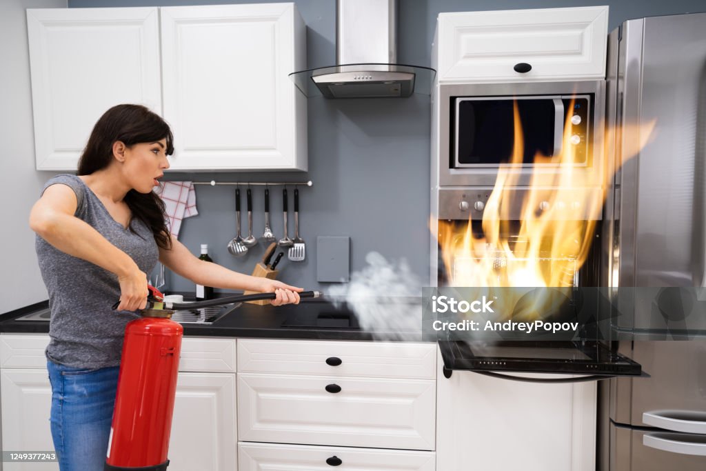 Hay una necesidad de archivo poco claro Mujer Usando Extintor De Incendios Para Apagar El Fuego Del Horno Foto de  stock y más banco de imágenes de Cocina - Estructura de edificio - iStock