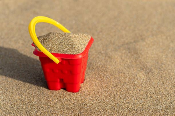 istock Red sand castle bucket on a sand background. Minimal summer vacation concept. 1249378283