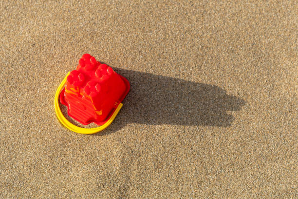 istock Red sand castle bucket on a sand background. Minimal summer vacation concept. 1249384074