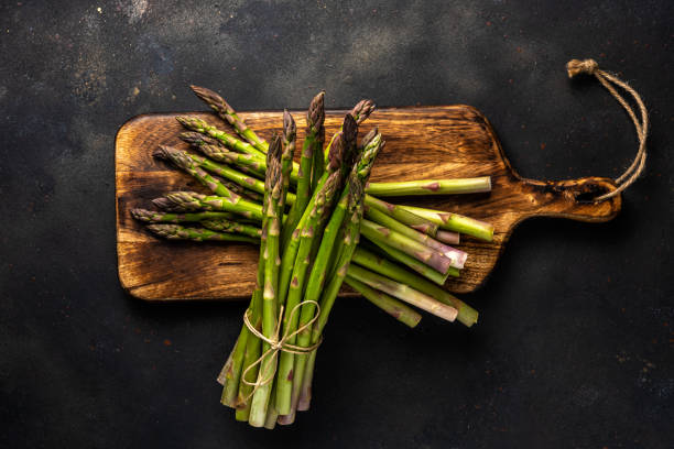 istock View of fresh asparagus on a black table. Food background. 1249384085