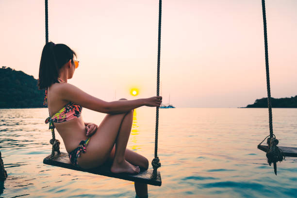 istock Woman on swing in beach 1249388437