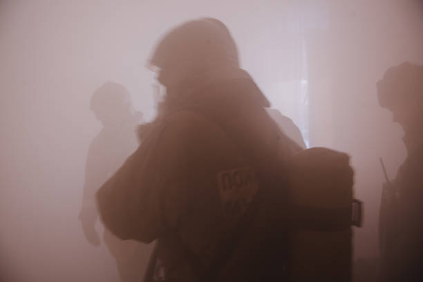 煙の中でシルエットフル投票率の消防士 - turnouts ストックフォトと画像