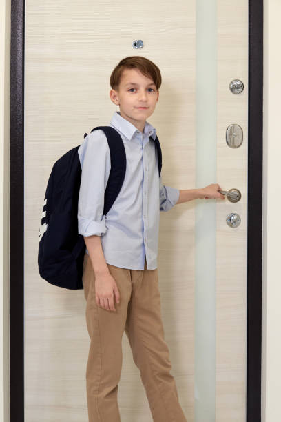 un beau garçon dans une chemise bleue avec un sac à dos sur le dos va à l’école. - schoolgirl child backpack book bag photos et images de collection