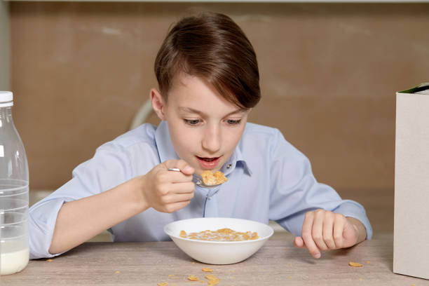 istock A boy sits in the kitchen and eats cornflakes with milk. 1249390888