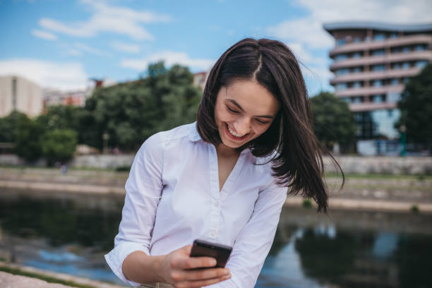 istock Beautiful woman texting by the river 1249392950
