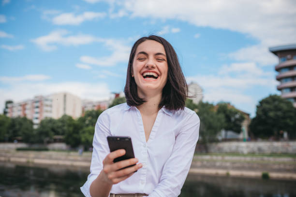 istock Beautiful woman texting by the river 1249393085