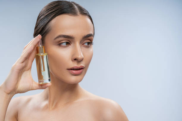 istock Calm young female using cosmetic treatment for face 1249394343