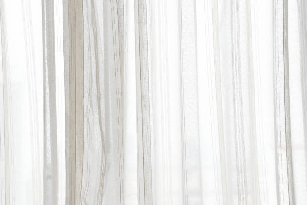 istock white curtain wavy with a pattern background. transparent curtain on window 1249400570