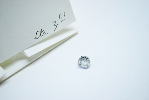 CVD HPHT Lab grown rough solitaire diamond with its parcel paper.