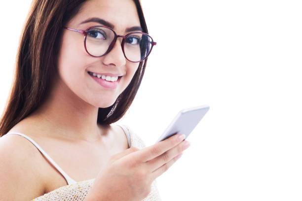 istock Female teenager chatting on smartphone facing camera smiling 1249402054