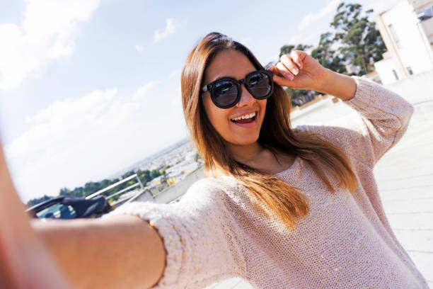 istock Beautiful young woman outside taking a selfie smiling at camera 1249402092