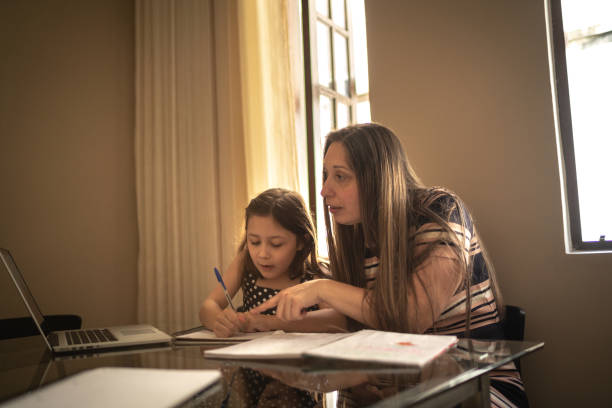 istock Mother helping daughter studying using laptop at home 1249402282