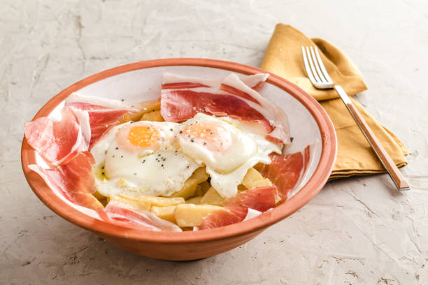 istock Broken fried eggs with potatoes and Iberian cured ham 1249402967