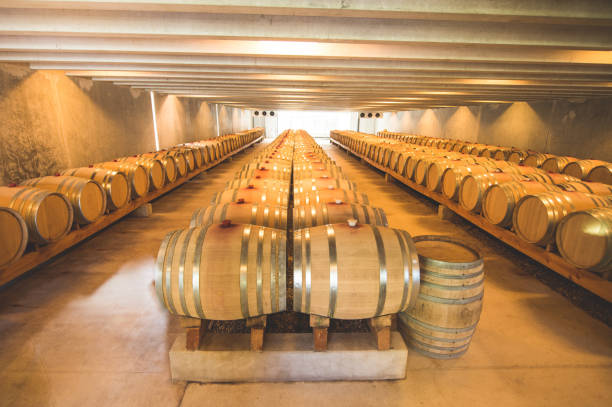 filas de barricas de roble apiladas que contienen vino madurante en una bodega. en la región de marlborough nueva zelanda - marlborough region zealand new new zealand fotografías e imágenes de stock