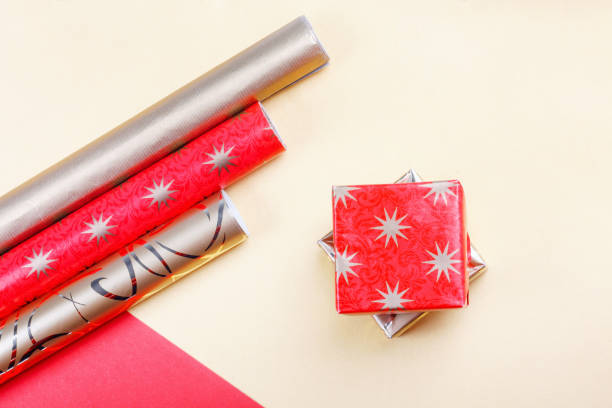istock Golden gift boxes and red wrapping paper on bright background 1249403406