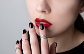 Beautiful young woman with bright makeup and black nail design