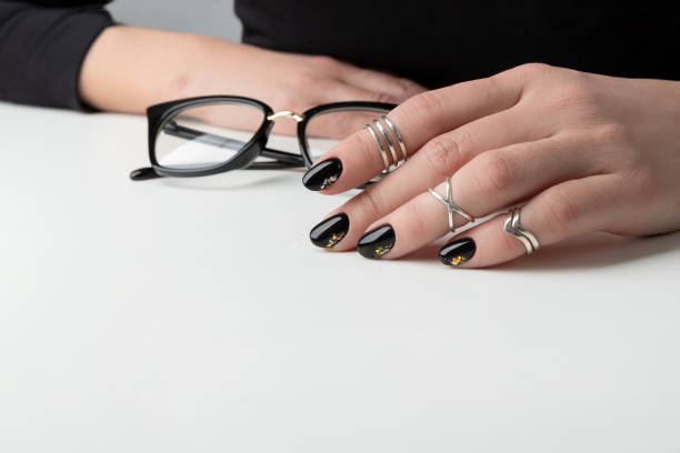 istock Beautiful womans hand with elegant manicure. Minimal black nail design 1249404121