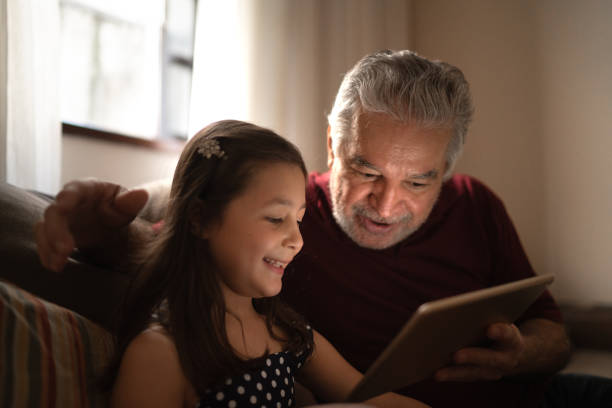 istock Grandfather and granddaughter using digital tablet at home 1249407311
