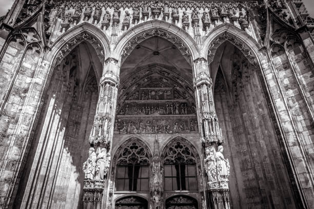 Ulm Minster or Cathedral of Ulm city, Germany. It is top landmark of Ulm. Front view of ornate entrance of old Gothic cathedral, Ulm Minster or Cathedral of Ulm city, Germany. It is top landmark of Ulm. Front view of ornate entrance of old Gothic cathedral, luxury facade of famous medieval Christian church in black and white. ulm minster stock pictures, royalty-free photos & images