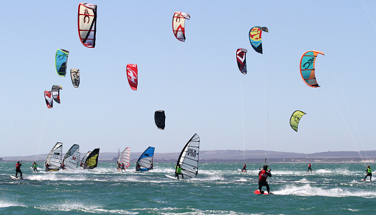 Langebaan, South Africa - 25 January 2014: Windsurfers and Kiteboarders in action on the water in the Langebaan Lagoon, South Africa.